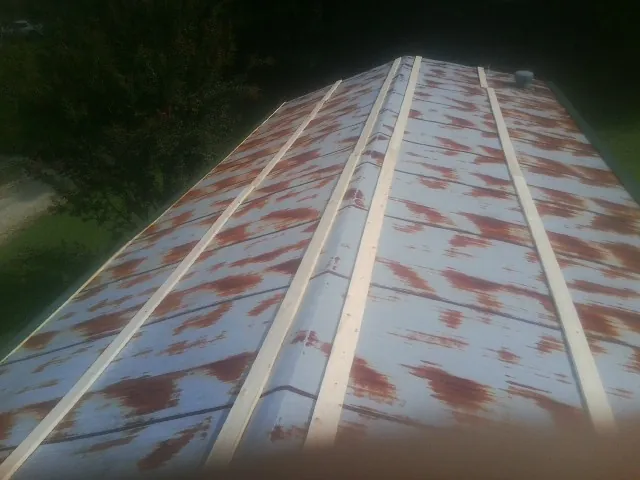 Rusted metal roof panels with new wood purlins before replacement — Storm Damage Roof Repair in Steger by Roofing Brothers