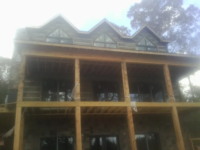 Dormers and porch framing on a large log home under construction — Roof Coating work by our crew in Steger