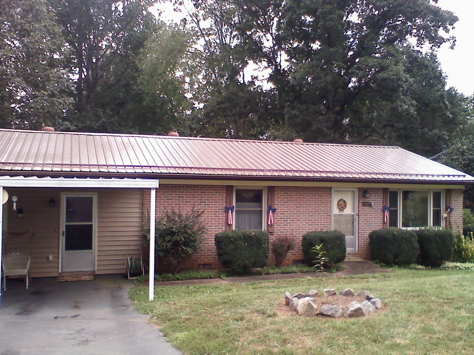Bronze metal roof and carport on a brick ranch home — Roof Repair work by our crew in Steger
